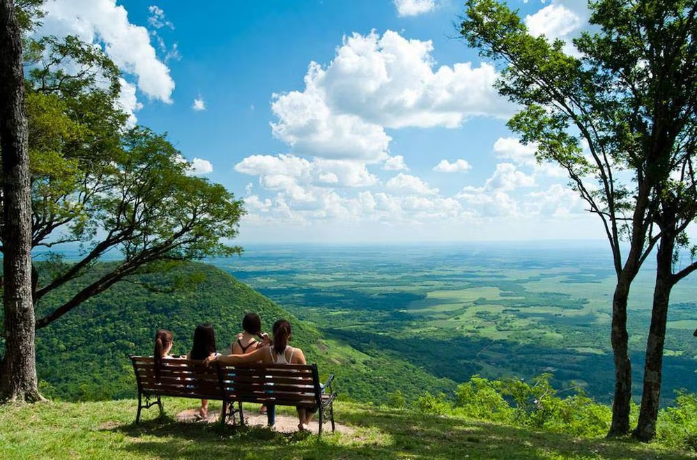 Una familia viendo el horizonte desde un monte verdoso en Paraguay