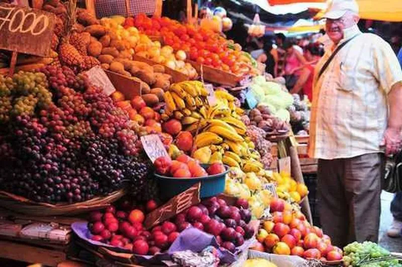 Hombre viendo frutas en el Mercado Cuatro