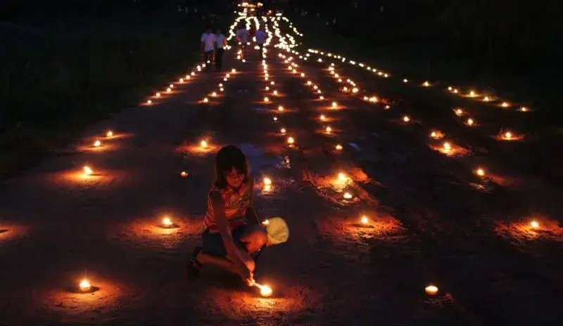 Una niña armando el camino de velas en la semana santa de Tañarandy.